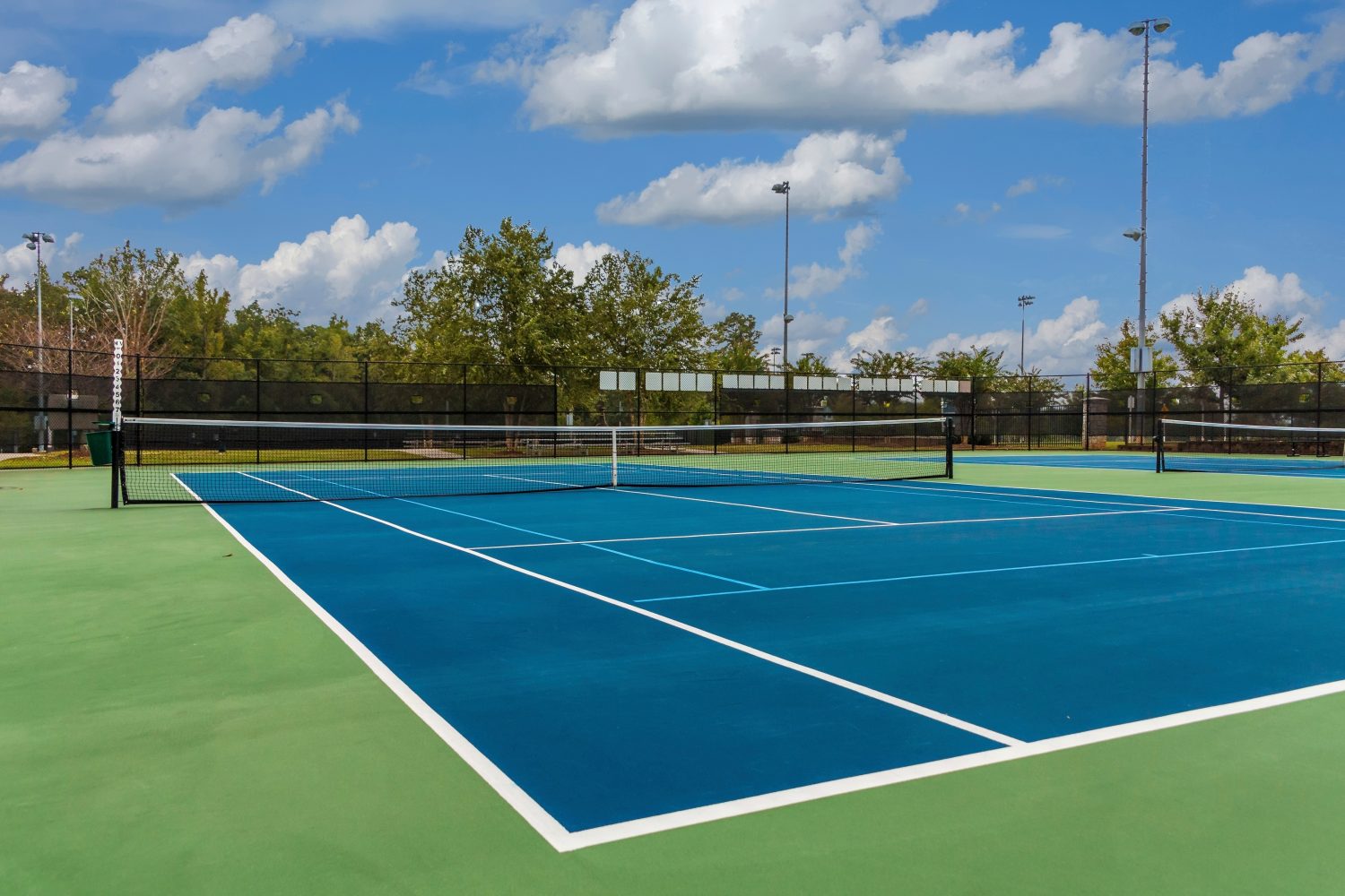 Tennis Court from Corner Outdoor tennis court in the sun, ideal example for facilities using tennis court booking software to manage reservations and access.