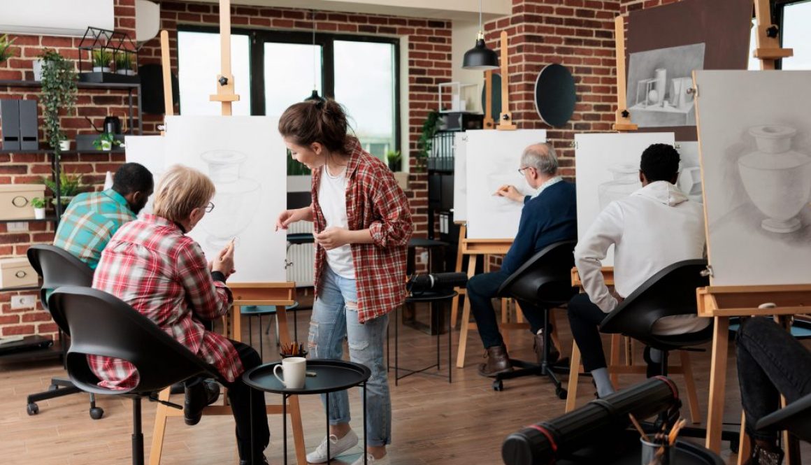 Senior woman attending an art class at a local community center - an example of programming managed through community center management systems.
