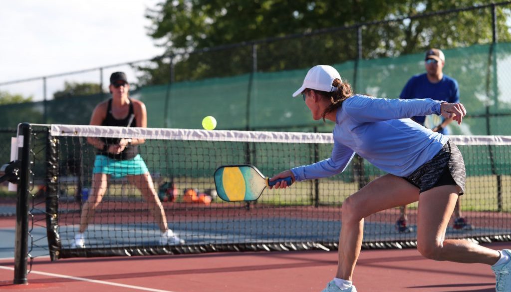 Pickleball player practicing a dink shot, highlighting the role of pickleball court reservation software in supporting the sport’s growth and accessibility.