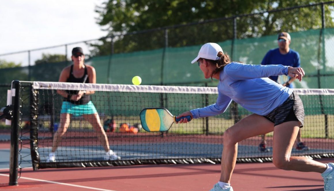 Pickleball player practicing a dink shot, highlighting the role of pickleball court reservation software in supporting the sport’s growth and accessibility.