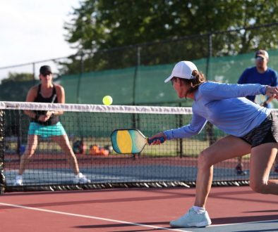 Pickleball player practicing a dink shot, highlighting the role of pickleball court reservation software in supporting the sport’s growth and accessibility.