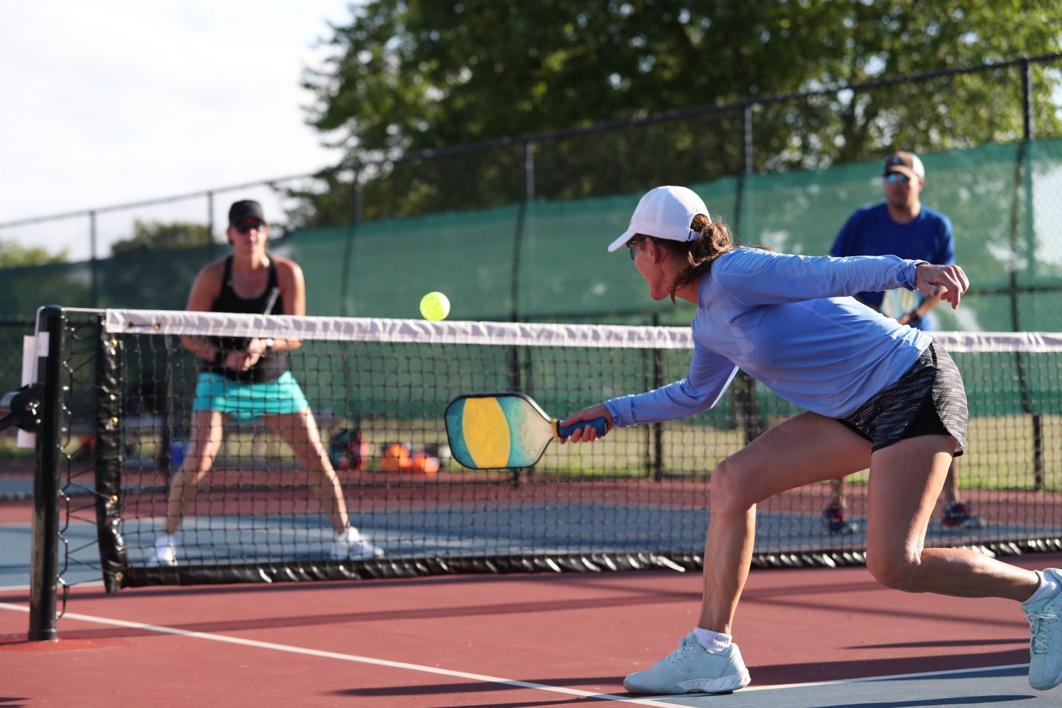 Pickleball player practicing a dink shot, highlighting the role of pickleball court reservation software in supporting the sport’s growth and accessibility.