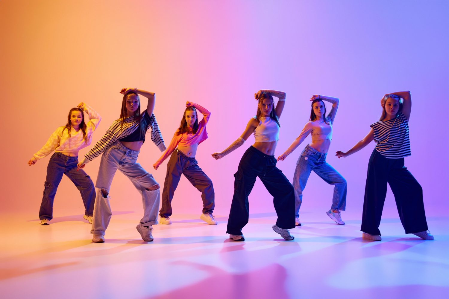 Group of active people, talented dancing hip hop against gradient studio background in neon light. Contemp Group of active people, talented dancing hip hop against gradient studio background in neon light. Contemp