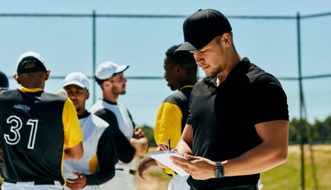 Baseball coach using team scheduling software to organize the roster and manage team schedules with players during a practice or tournament