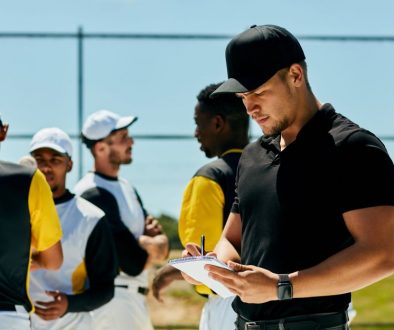 Baseball coach using team scheduling software to organize the roster and manage team schedules with players during a practice or tournament