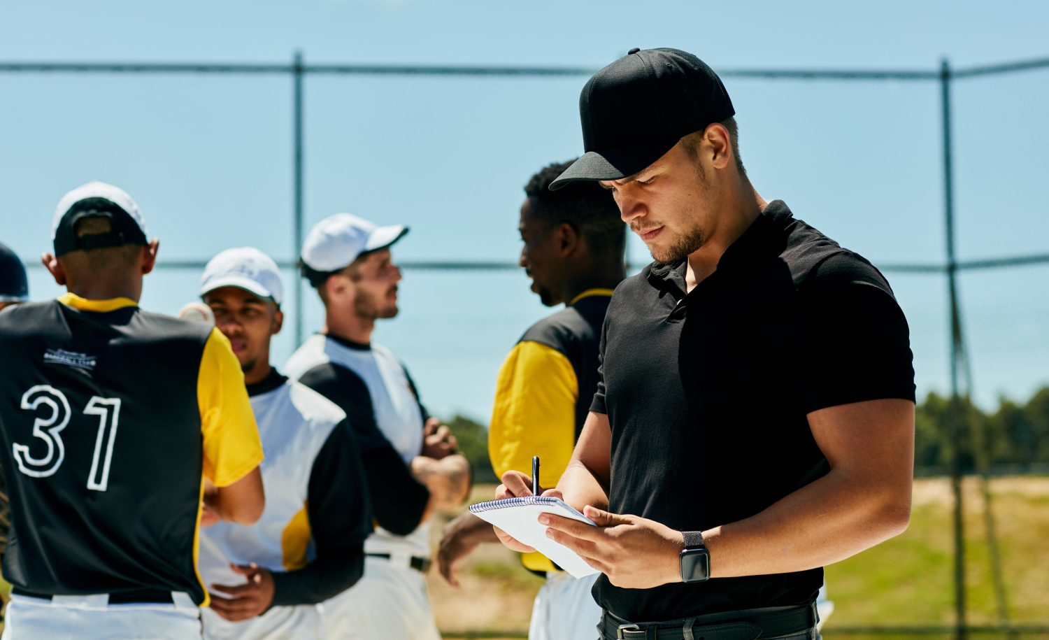 Baseball coach using team scheduling software to organize the roster and manage team schedules with players during a practice or tournament