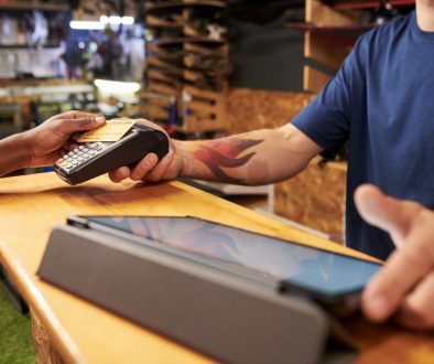 Young Man Assisting Black Man Making Contactless Payment