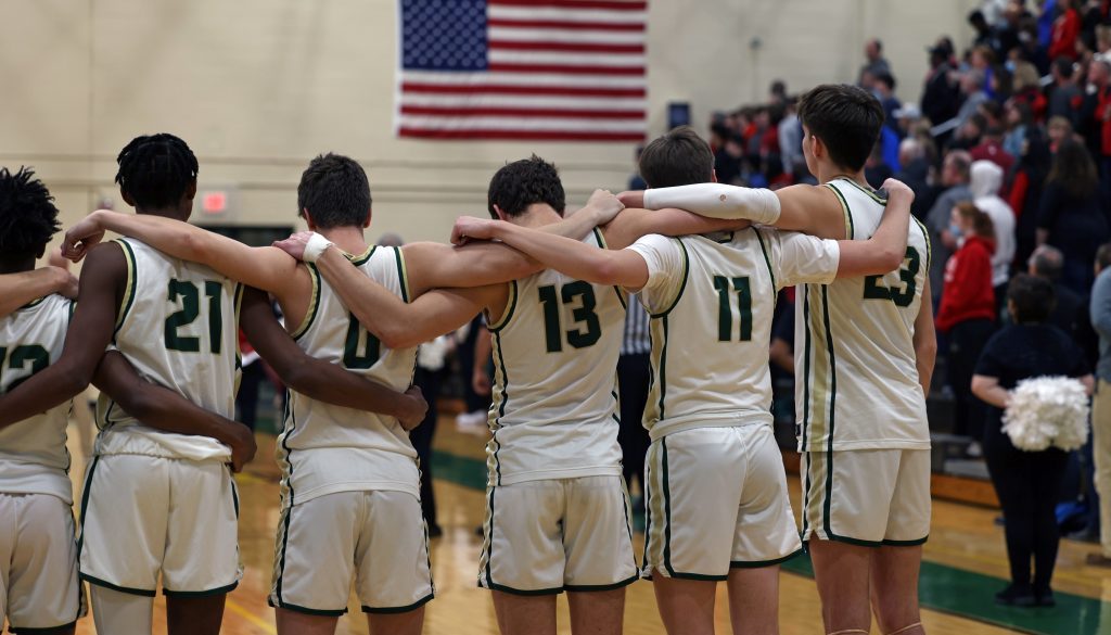 A basketball team stands during the National Anthem