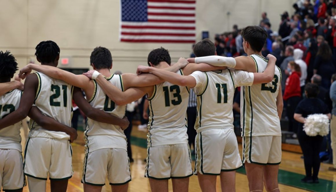 A basketball team stands during the National Anthem