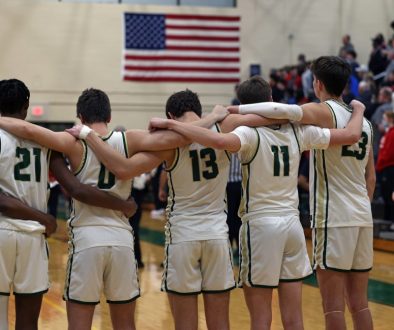 A basketball team stands during the National Anthem