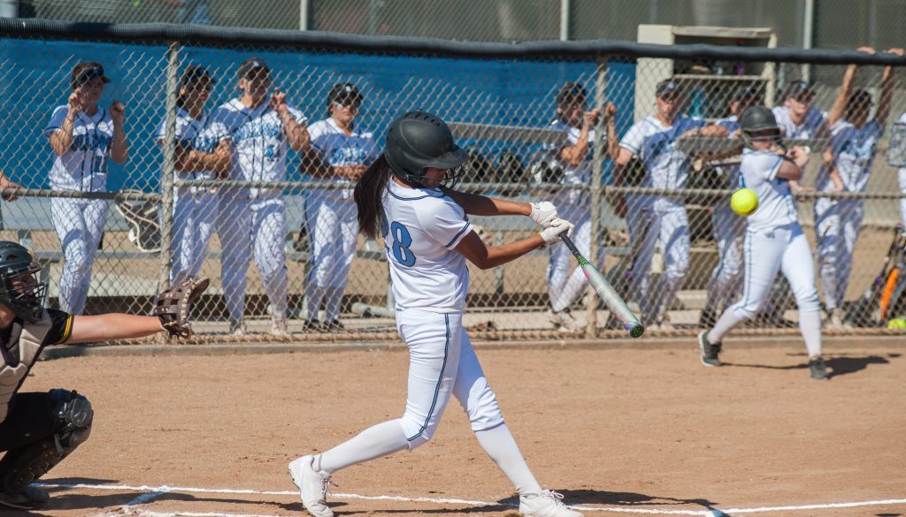 Filipino softball batter hitting a line drive during a game, representing softball team management software and player development.
