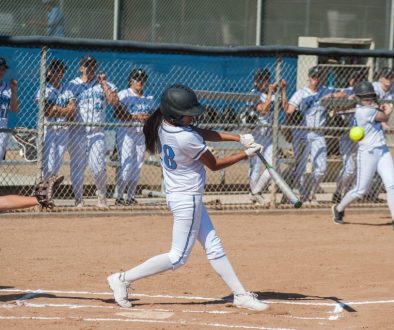 Filipino softball batter hitting a line drive during a game, representing softball team management software and player development.